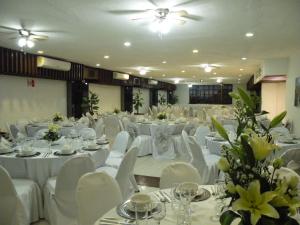 a banquet hall with white tables and white chairs at Hotel Palacio in Córdoba