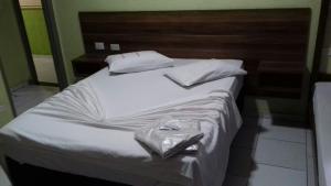 a large bed with white sheets and white pillows at Hotel Michel in São Paulo
