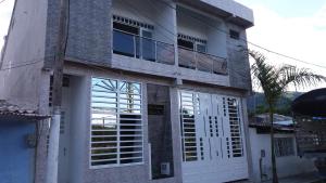 un edificio con puertas blancas y balcón en Casa Campestre La Heredera en Villavicencio
