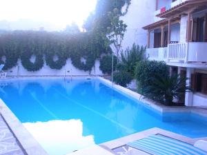 a large blue swimming pool next to a building at Captain's House Hotel in Skala