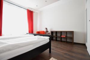 um quarto com uma cama e uma cadeira vermelha em Standard Apartment by Hi5 - Close to Buda Castle em Budapeste