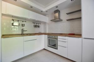 una cocina blanca con armarios blancos y fregadero en Standard Apartment by Hi5 - Close to Buda Castle, en Budapest