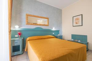 Schlafzimmer mit einem Bett und einem Wandspiegel in der Unterkunft Hotel San Francisco in Cala Gonone