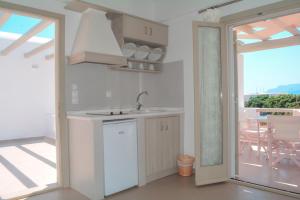 a kitchen with a sink and a door to a patio at Notos Studios in Schinoussa