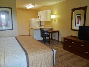 a hotel room with a bed and a desk and a kitchen at Extended Stay America Suites - Sacramento - Arden Way in Sacramento