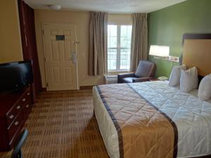 a hotel room with a bed and a television at Extended Stay America Suites - Sacramento - Arden Way in Sacramento