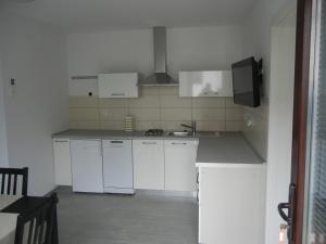 a kitchen with white cabinets and white appliances at Rooms & Apartment Mira G. in Postojna