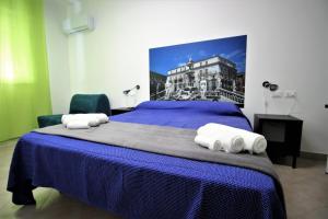 パレルモにあるInto Palermo B&Bのベッドルーム1室(ブルーベッド1台、タオル付)
