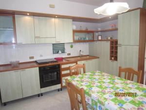 a kitchen with a table and a kitchen with white cabinets at Casa Mare di Ponente in Erice