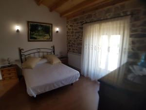 een slaapkamer met een bed en een stenen muur bij Casa Rural del Tormes in Puente del Congosto