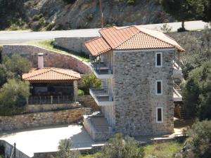 een extern uitzicht op een stenen huis met een dak bij Labetia Apartments in Áyioi Apóstoloi