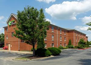 a red brick building with a tree in front of it at Extended Stay America Select Suites - Memphis - Cordova in Memphis