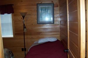 a corner of a room with a bedroom with wooden walls at Hyde County Lodges in Engelhard