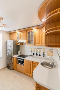 a kitchen with wooden cabinets and a stainless steel refrigerator at VIP Apartment ob Gorkogo Square in Sumy