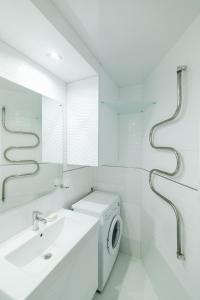 a bathroom with a sink and a washing machine at VIP Apartment ob Gorkogo Square in Sumy