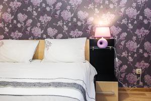 スームィにあるVIP Apartment ob Gorkogo Squareのベッドルーム1室(ランプと紫の壁紙のベッド1台付)
