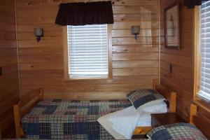 a bedroom with a bed in a log cabin at Hyde County Lodges in Engelhard