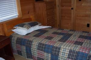 una camera con un letto con una coperta a quadri di Hyde County Lodges a Engelhard