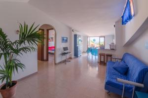 un soggiorno con divano blu e tavolo di Casa Vacanze "Ro & Se" a Palinuro IT, Bandiera Blu anche per il 2024 a Palinuro