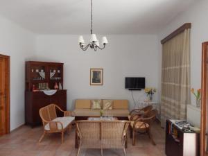 - un salon avec un canapé, une table et des chaises dans l'établissement Kaina Villa, à Vámos
