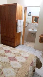 y baño con cama, lavabo y ducha. en Green Haven Cottage, en Les Coteaux