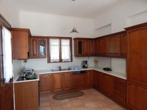 a kitchen with wooden cabinets and a sink at Kaina Villa in Vamos