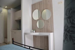 ein Badezimmer mit einem Waschbecken und zwei Spiegeln an einer Wand in der Unterkunft Levante Sea View Studios in Stalida