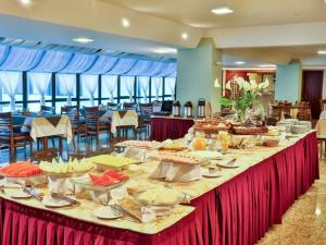 a long table with food on it in a restaurant at Hotel Home Green Home in Campos do Jordão