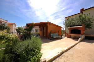 a backyard with a wooden deck with a fireplace at Valadar Apartments in Privlaka