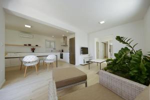 a living room with a table and chairs and a kitchen at Valadar Apartments in Privlaka