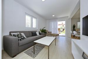 a living room with a couch and a table at Valadar Apartments in Privlaka