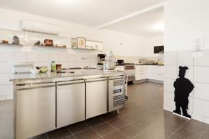 una cocina con electrodomésticos blancos y una persona en el medio en La Maison de Karen Chocolat, en Limonest