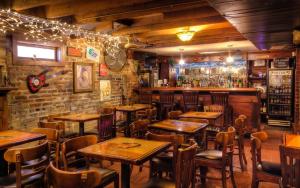 un restaurante con mesas y sillas de madera y un bar en Olde Town Inn en Augusta