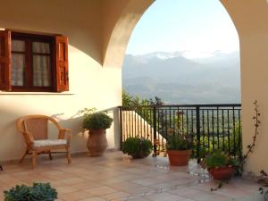 a balcony with a chair and potted plants at Kaina Villa in Vamos