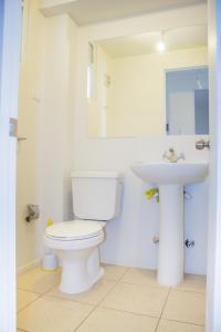 une salle de bain avec des toilettes blanches et un lavabo dans l'établissement Condominio Mistral V, à La Serena