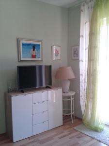soggiorno con TV su un armadio bianco di Apartment Splitska a Splitska