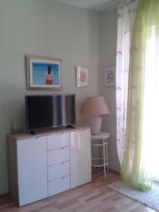 a living room with a television on a white cabinet at Apartment Splitska in Splitska