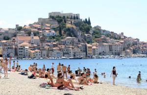 a crowd of people on a beach with a city at Apartment Andrija in Šibenik