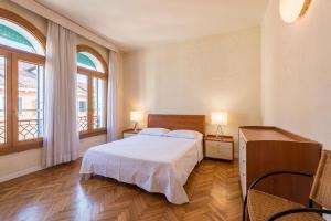 ヴェネツィアにあるAppartamento Mashaのベッドルーム1室(ベッド1台、窓2つ付)