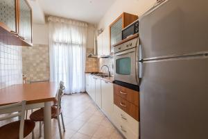 uma cozinha com uma mesa e um frigorífico de aço inoxidável em Appartamento Masha em Veneza