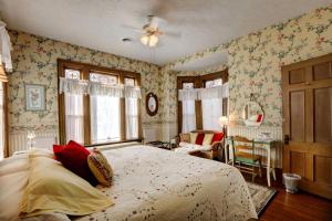 1 dormitorio con 1 cama grande y papel pintado con motivos florales en Barrister's Bed & Breakfast, en Seneca Falls