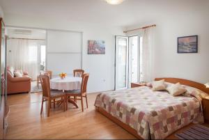 a bedroom with a bed and a table and chairs at Apartments Cvjetni Dvori in Makarska