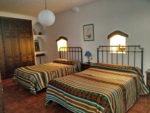 two beds in a room with two at Casas Rurales Encarnita in Bubión