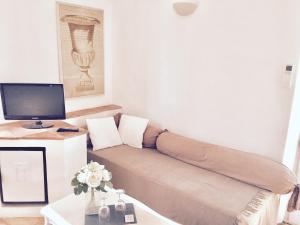 a small living room with a couch and a computer at Le Mas d'Olivier in Le Plan-de-la-Tour