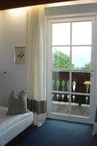 a bedroom with a large window with a view of a balcony at Hotel Latemar in Soprabolzano