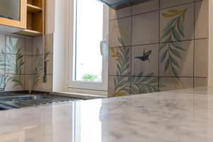 a kitchen with a tile wall with a bird on it at Casa Colibrì - Solemar Sicilia in Santa Flavia