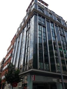 un edificio di alto vetro su una strada di città di Apartamento Las 4 Palmeras a Cordoba