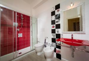 a bathroom with a red sink and a toilet and a shower at Cineholiday House 1 in Castellammare del Golfo