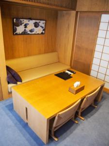 une table en bois avec un banc et une boîte sur celle-ci dans l'établissement Ayame-an, à Kyoto