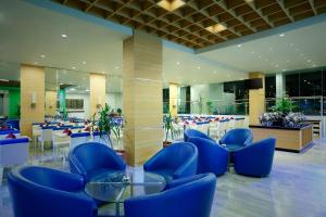 eine Lobby mit blauen Stühlen und Tischen in einem Gebäude in der Unterkunft BATIQA Hotel & Apartments Karawang in Karawang
